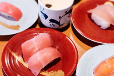 Suşi ve Sashimi. Suşi ve Sashimi tabakları taşıma bandında yuvarlanıyor..