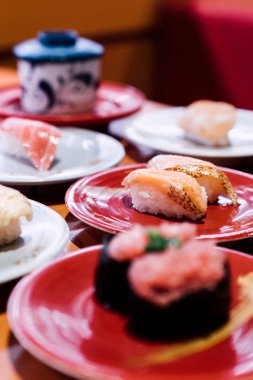 Suşi ve Sashimi. Suşi ve Sashimi tabakları taşıma bandında yuvarlanıyor..