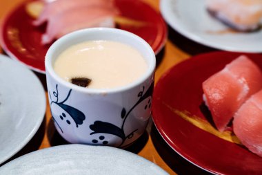 Suşi ve Sashimi. Suşi ve Sashimi tabakları taşıma bandında yuvarlanıyor..