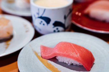 Suşi ve Sashimi. Suşi ve Sashimi tabakları taşıma bandında yuvarlanıyor..