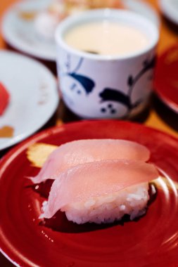 Suşi ve Sashimi. Suşi ve Sashimi tabakları taşıma bandında yuvarlanıyor..