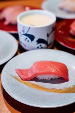 Suşi ve Sashimi. Suşi ve Sashimi tabakları taşıma bandında yuvarlanıyor..