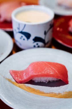 Suşi ve Sashimi. Suşi ve Sashimi tabakları taşıma bandında yuvarlanıyor..