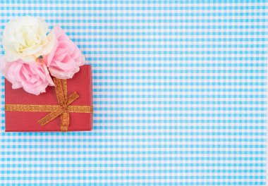 Ekose arka planda kırmızı izole edilmiş hediye kutusu. Anneler Günü ya da Kadınlar Günü için bayram süsü..