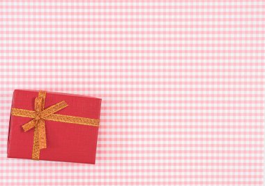 Ekose arka planda kırmızı izole edilmiş hediye kutusu. Anneler Günü ya da Kadınlar Günü için bayram süsü..
