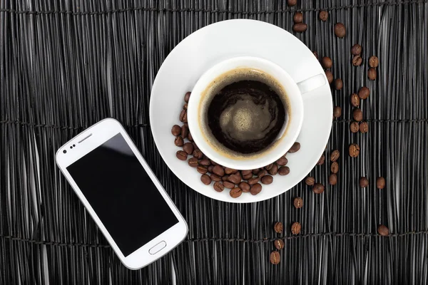 Кофе с кофейными зернами и смартфоном — стоковое фото