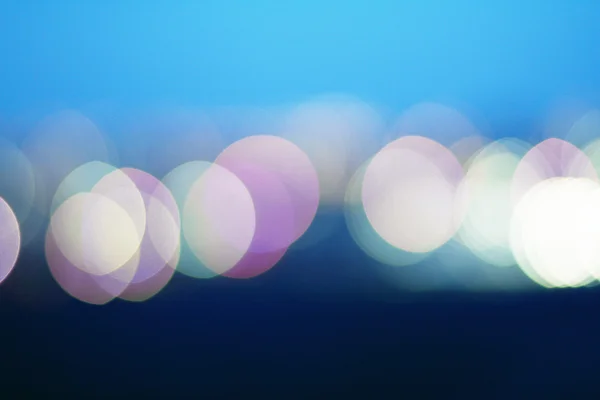 ボケ効果ライト シアンと紫の点灯青色の背景 — ストック写真