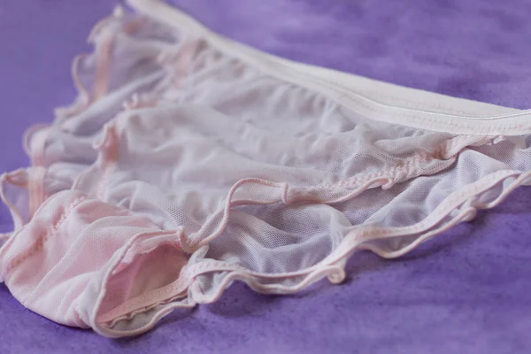 Sexy ropa interior transparente rosa sobre fondo púrpura Fotos de stock libres de derechos