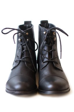 Female pair of black boots with shoelaces tied close up clipart