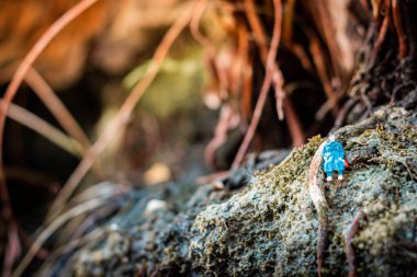 Minyatür insanlar, kayanın üzerinde ışık saçan kadınlar.