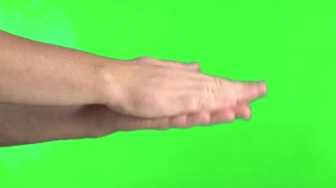Yeşil bir ekranın arka planına karşı ellerini çırpar
