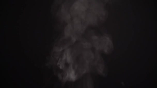 Vapor de agua hirviendo. Humo gris atmosférico realista con salpicaduras sobre un fondo negro — Vídeos de Stock