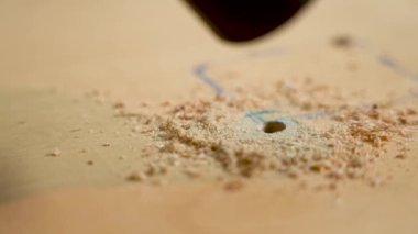 Elektrikli süpürge ahşap kontrplak delikleri açtıktan sonra talaş emer.