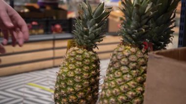 Erkek el süpermarkette ananas seçiyor..