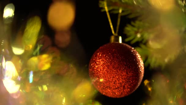 Pelota roja mate en el primer plano del árbol de Navidad. Fabuloso Bokeh mágico. Concepto de Fiestas y Celebraciones de Navidad — Vídeos de Stock
