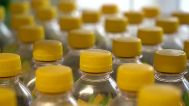 Vitrinin yanındaki dükkanda bir sürü plastik içki şişesi var. Yakından çek. Karbonatlı meşrubat şişeleri.