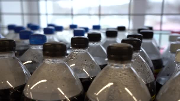 Lots of plastic drinks bottles in the shop by the window. CLOSE-UP. Row of carbonated soft drink bottles — Stock Video