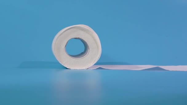 Um rolo de papel higiênico isolado no fundo azul — Vídeo de Stock