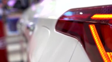 Yeni Araba Sergisi 'nin arka lambası bir araba galerisinde. Yeni modern arabanın arka manzarası, galeride LED stop lambaları.