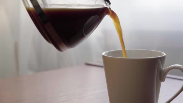 Vierta el café negro en una taza de una cafetera. Beber café fresco por la mañana — Vídeos de Stock