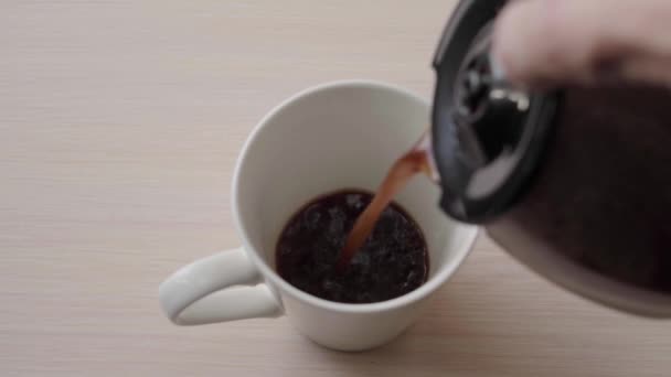 Vierta el café negro en una taza de una cafetera. Beber café fresco por la mañana — Vídeos de Stock