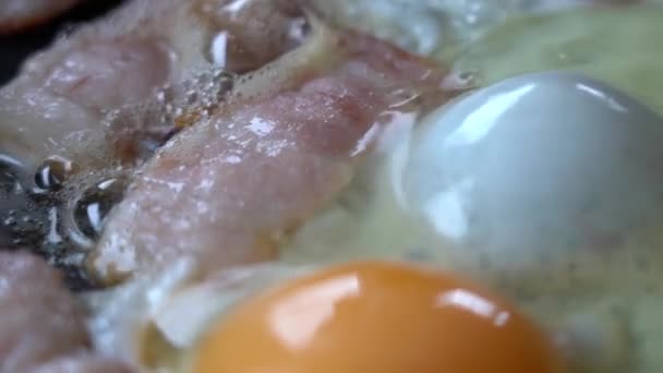 BACON dan EGG adalah COOKED dalam wajan. Potongan daging dan telur dalam wajan panas, close-up. Pencahayaan Alami dari jendela — Stok Video