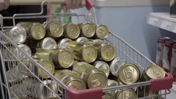Süpermarkette market arabasında bir sürü altın bira kutusu var. — Stok video