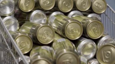 Süpermarkette market arabasında bir sürü altın bira kutusu var.