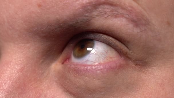 Der Augapfel eines Mannes mit braunen Augen schaut auf — Stockvideo