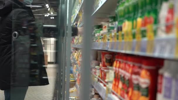 Медленное движение. Крупный план. Долли Шот. Мужчина открывает стеклянную дверь холодильника в супермаркете. Камера проникает в холодильник — стоковое видео