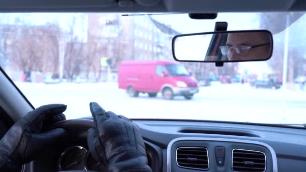 Bloccato nel traffico in inverno. Mani da uomo sul volante. Vista sulla spalla dei conducenti. L'auto viaggia in inverno — Video Stock