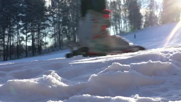 Ormanın Arkasında Kayak Yamacı. Bir kayakçının bacakları asansörle yukarı çıkıyor. Kayak Botları Yakın plan — Stok video