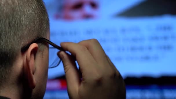 안경을 쓴 남자가 고속 뉴스 피드로 대형 스크린을 보고 있습니다. 개념: 대중 매체를 통해 정보를 얻을 수있는 엄청난 기회 — 비디오