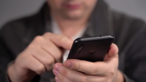 The mans hands are holding a smartphone. The man uses a smartphone — Stock Video