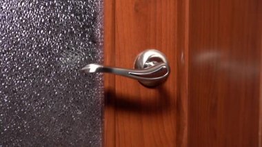 Bir kadın eli kapıyı çalar ve açar.
