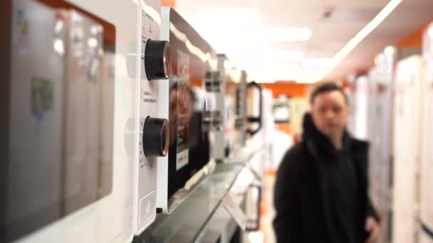 Man väljer en mikrovågsugn ugn i en butik — Stockvideo