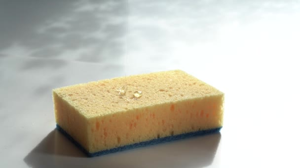 Giet de gel op de spons. Transparante afwasgel wordt in een gele poreuze spons gegoten. — Stockvideo