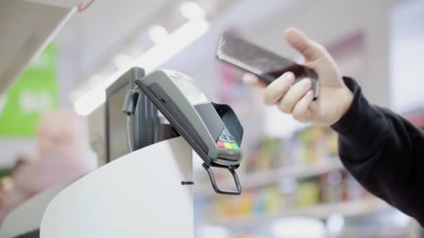 Pague por mercadorias através do terminal de uma forma contactless em um supermercado. Usando wireless moderno e conveniente — Vídeo de Stock