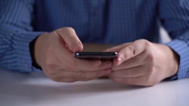 Kadın elleri kullanıyor, cep telefonunu açık bir kitapla tutuyor.