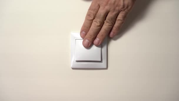 Hand älterer Mann schaltet Licht aus und schaltet Wandschalter ein — Stockvideo