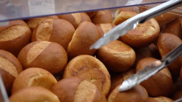 Prenez des rouleaux de pain avec des pinces à pain. J'achète du pain. Mouvement lent. — Video