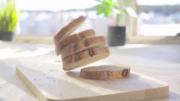 Gesneden wit brood vallen op de tafel in slow motion — Stockvideo