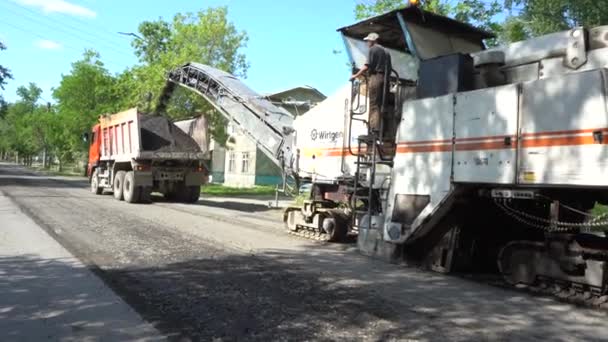 Ekaterimburgo, Rusia - Julio 2019. Cargando asfalto viejo en un camión volquete. Trabajos de reparación de carreteras — Vídeo de stock