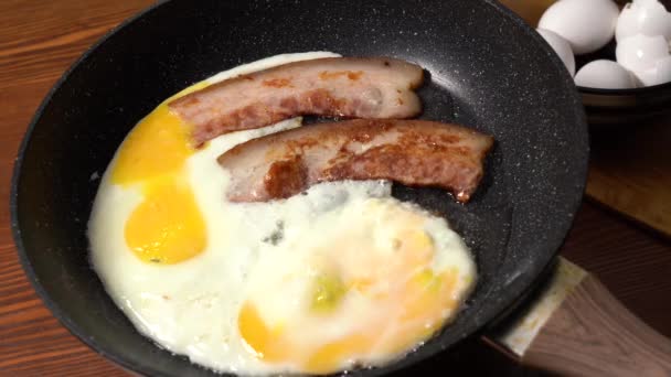 Huevos fritos con tocino en una sartén. Primer plano — Vídeos de Stock