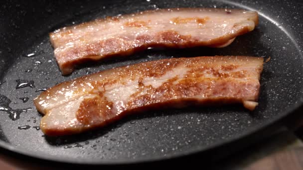 Vista de perto das fatias de bacon na frigideira. — Vídeo de Stock