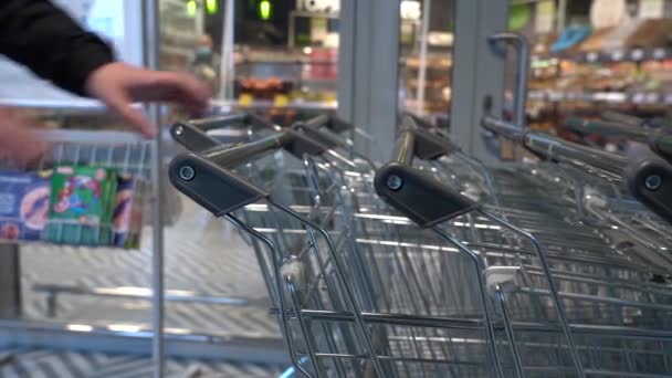Ambil Kereta Grosir untuk Belanja. Penutup-up Male Hand Shopper Menarik Keranjang Belanja dari Baris di Supermarket atau Toko Grosir — Stok Video