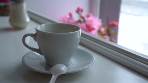 Becher Heißgetränk auf dem Tisch neben dem Fenster in der Konditorei — Stockvideo