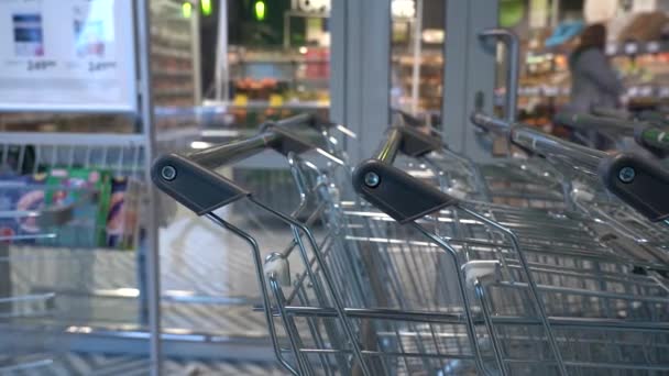男子手拉手在超市或杂货店排队等候空购物车的特写镜头 — 图库视频影像