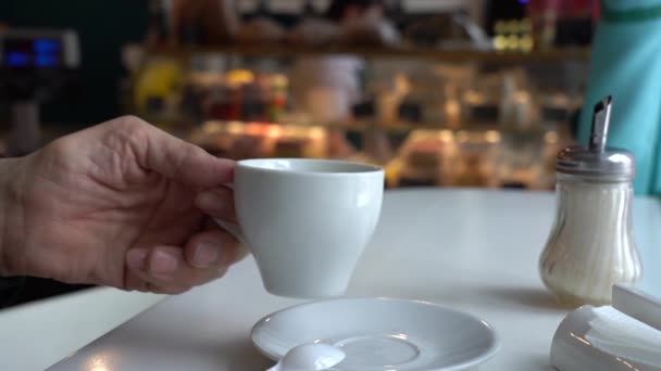 Der alte Mann trinkt Kaffee in einem Café. — Stockvideo