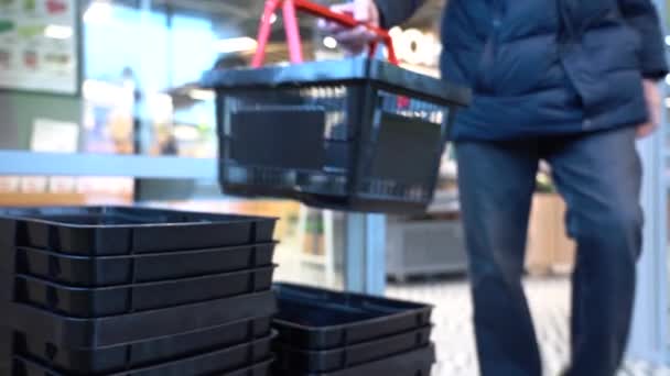 Close-up van een winkelend mannetje die een lege kruidenierswagen in een supermarkt of kruidenier opstelt — Stockvideo